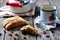 Homemade biscotti with dried cranberries and lime, with a cup of green tea kettle on the wooden table