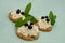 Homemade biscuits and soft white cheese cakes, decorated with blueberries and green leaves. Delicious food with crumbs on blue