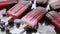 Homemade blackberry and cream ice-creams or popsicles with frozen berries on black slate tray