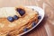 Homemade blinis or crepes with blueberries and jam toned photo