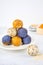 Homemade blue matcha butterfly pea tea powder energy balls in a ceramic plate healthy sweets made of nuts, dry apricots, sesame.