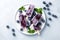 Homemade blueberry yogurt popsicles on a plate with ice and fresh berries, generative AI