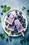 Homemade blueberry yogurt popsicles on a plate with ice and fresh berries, generative AI