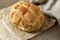 Homemade Boule Round Loaf Bread on Brown Paper, Rustic Wooden Table