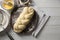 Homemade braided bread and ingredients on white wooden table, flat lay. Cooking traditional Shabbat challah