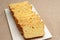 Homemade Brazilian corn bread sliced on a cutting board. Isolated on jute background