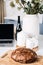 Homemade Bread on Kitchen Table with Laptop. Freshly baked homemade bread on a cutting board beside a laptop, depicting