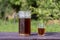 Homemade bread kvass with leaven and malt in a glass jug in garden, close up