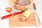 Homemade bread with tomato and cheese and wicker basket with napkin on white table with bread knife and red knife for tomato