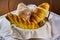 Homemade breads. different types of home-made breads in basket on white tablecloth on wooden table