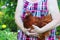 A homemade brown chicken sits in the hands of an elderly woman, and the grandmother holds the chicken