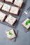 Homemade brownie with coconut flakes, swedish dessert Karleksmums, cut in square servings, on stone plate and cooling rack,