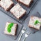 Homemade brownie with coconut flakes, swedish dessert Karleksmums, cut in square servings, on a stone plate and cooling rack, top