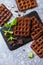 Homemade brownie waffles. Chocolate Belgian waffles with chocolate topping on a stone or slate table.