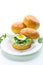 Homemade bun with cheese spread, fresh arugula and boiled egg in a plate