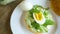 Homemade bun with cheese spread, fresh arugula and boiled egg in a plate