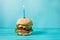 Homemade burger barbeque sandwich with beef and lit candle for birthday party on blue background. Concept holiday