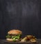 Homemade burger with tuna and fried potatoes with dill and garlic on a cutting board wooden rustic background border, place for