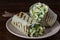 Homemade burrito wraps with green cabbage, cucumber, herbs and sour cream for healthy breakfast on plate, closeup