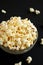 Homemade Buttered Popcorn with Salt in a Bowl on a black background, low angle view