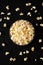 Homemade Buttered Popcorn with Salt in a Bowl on a black background, top view. Flat lay, overhead, from above