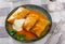 Homemade cabbage rolls in leaves of cabbage at plate with sour cream