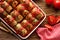 Homemade cabbage rolls stuffed with groats and mushrooms with tomato sauce in a baking dish on a wooden table