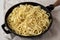 Homemade Cacio E Pepe Pasta with Pecorino Romano and Pepper in a cast-iron pan, side view