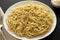 Homemade Cacio E Pepe Pasta with Pecorino Romano and Pepper on a white plate on a black background, side view