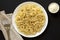 Homemade Cacio E Pepe Pasta with Pecorino Romano and Pepper on a white plate on a black surface, top view