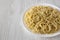 Homemade Cacio E Pepe Pasta with Pecorino Romano and Pepper on a white plate, side view. Copy space