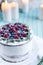 Homemade cake decorated berries on plate over wooden turquoise background