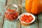 Homemade candied pumpkin pieces in glass jar and white plate wit