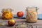 Homemade canned cabbage with apples in jars with bay leaves on a wooden table. Rustic style