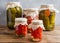 Homemade canned vegetables in cans. Pickled tomatoes and cucumbers in a rural style.