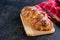 Homemade challah, traditional wicker white bread on a wooden board on a black concrete background