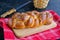 Homemade challah, traditional wicker white bread on a wooden board on a black concrete background