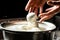 The homemade cheese maker produces handmade mozzarella with fresh bio milk. process of making mozzarella. Italian hard cheese