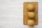 Homemade cheeseburgers on a bamboo board over white wooden background, overhead view. Flat lay, from above, top view. Copy space