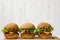 Homemade cheeseburgers on bamboo board, side view. Close-up