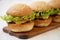 Homemade cheeseburgers on rustic wooden board, side view. Close-up. Selective focus