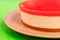 Homemade cheesecake with watermelon jelly on the top, on a bright contrasting green background