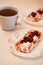 Homemade cheesecakes made from cottage cheese with sour cream and rasberry jam. A cup of tea in the background