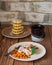 Homemade cheesecakes on two plates with frozen sea buckthorn berries and a coffee mug