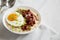 Homemade Cheesy Bacon Savory Oatmeal Bowl on cloth, low angle view. Copy space