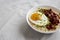 Homemade Cheesy Bacon Savory Oatmeal Bowl on cloth, low angle view. Copy space