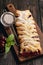 Homemade cherry puff pastry braid, on blue wooden background.