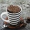 Homemade chocolate aromatic mug cupcake in a stylish gray striped mug on a gray stone background with bits of bitter