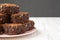 Homemade chocolate brownies on a pink plate, side view. Space for text