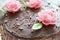 Homemade chocolate cake decorated with edible roses and leaves.